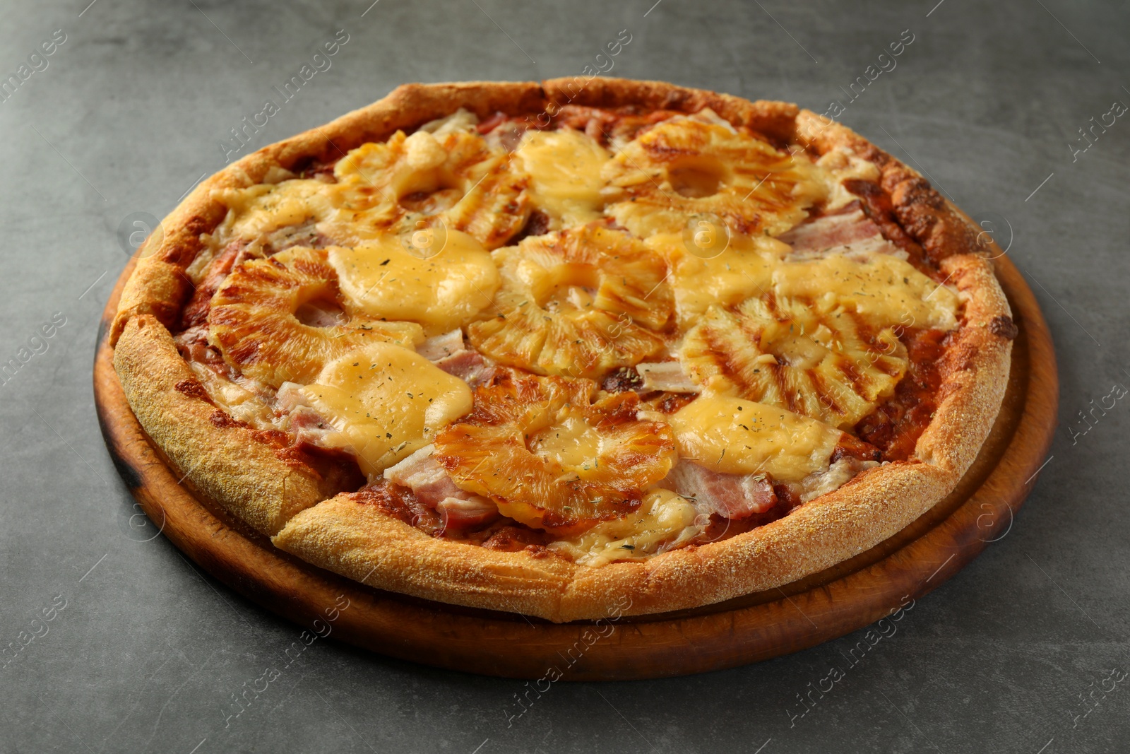 Photo of Delicious pineapple pizza on gray table, closeup