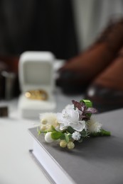 Wedding stuff. Composition with stylish boutonniere on white surface, closeup