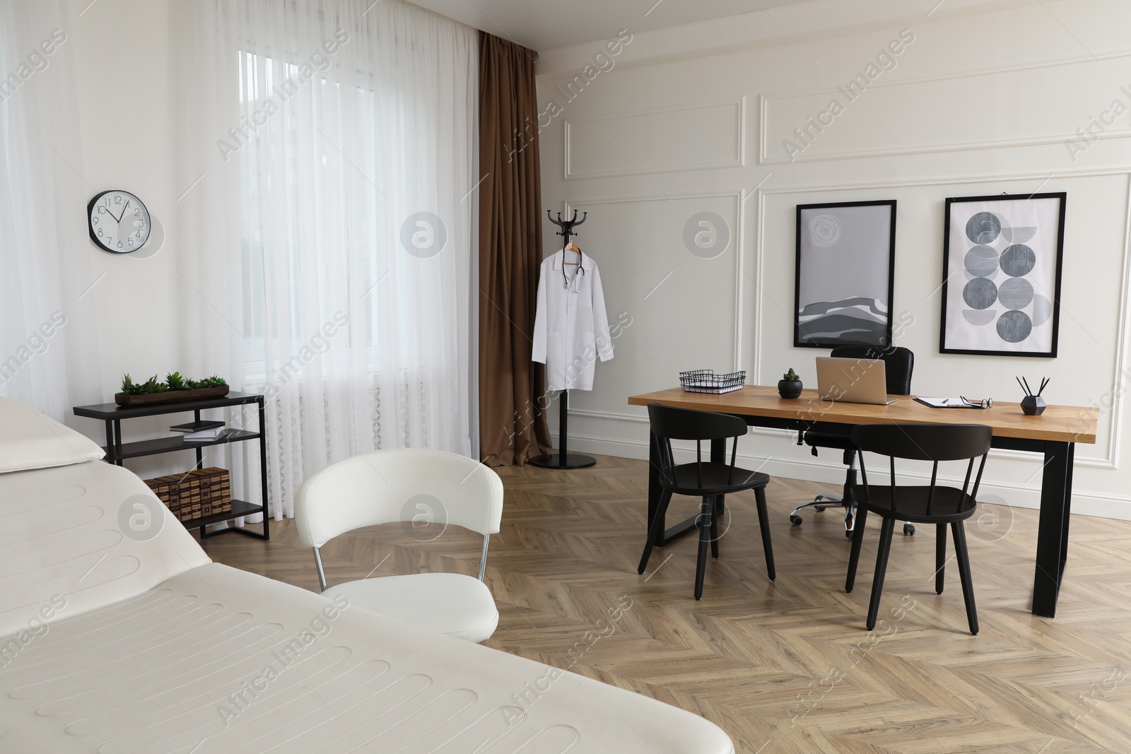 Photo of Modern medical office interior with doctor's workplace and examination table