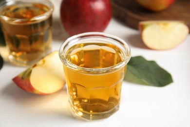 Photo of Glass of delicious apple cider on white table