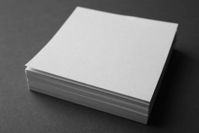 Photo of Blank note papers on dark grey background, closeup. Mock up for design