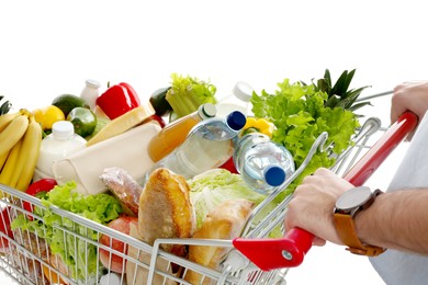 Man with shopping cart full of groceries on white background, closeup