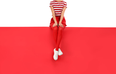 Photo of Woman wearing red tights and stylish shoes sitting on color background, closeup