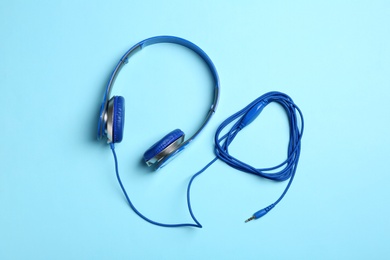 Photo of Stylish headphones on color background, top view