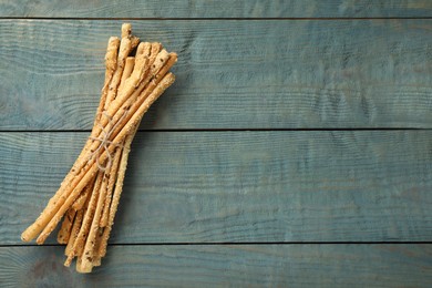 Photo of Delicious grissini sticks on wooden table, top view. Space for text