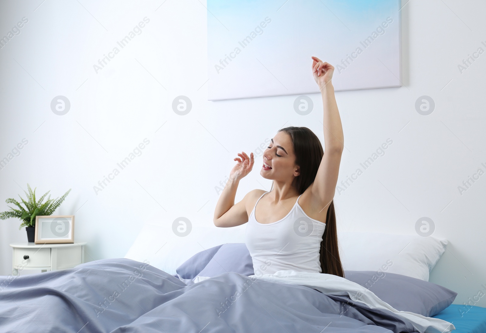 Photo of Young woman stretching at home in morning. Bedtime