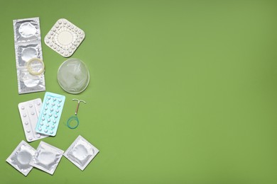 Photo of Contraceptive pills, condoms and intrauterine device on olive background, flat lay and space for text. Different birth control methods