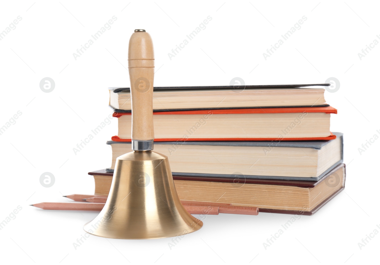 Photo of Golden school bell with wooden handle and stack of books on white background