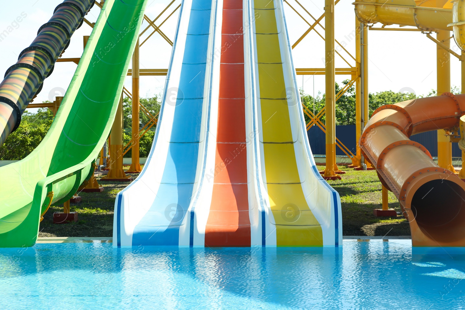 Photo of Different colorful slides and swimming pool in water park on sunny day