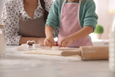Photo of Mother and daughter making pastry in kitchen at home, closeup