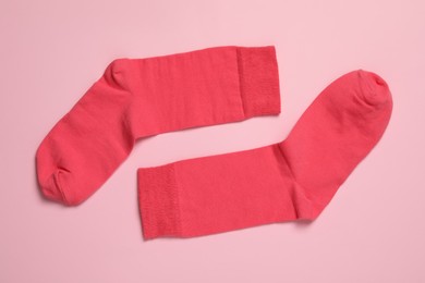Photo of Pair of new socks on pink background, flat lay