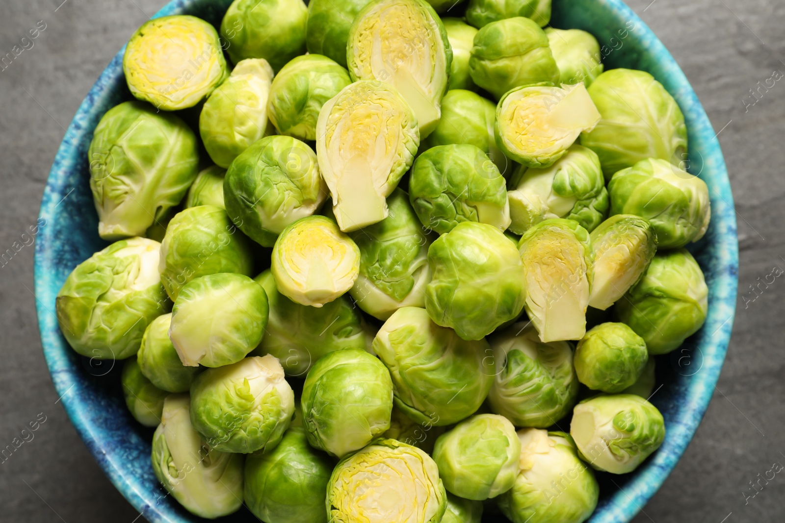 Photo of Bowl with fresh Brussels sprouts on table, top view