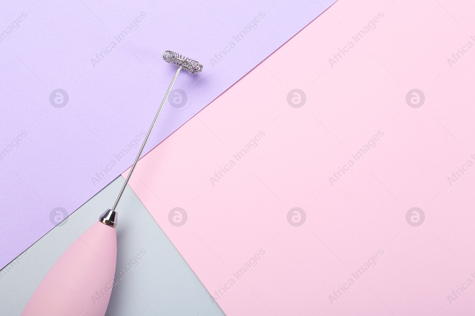 Photo of Pink milk frother wand on color background, top view. Space for text