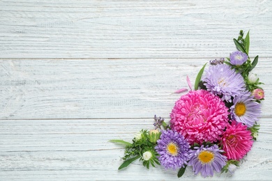 Photo of Flat lay composition with beautiful aster flowers on white wooden table. Space for text