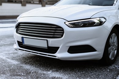 Modern white car outdoors on snowy day, closeup