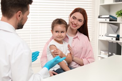 Children's hepatitis vaccination. Mother with her daughter and doctor in clinic