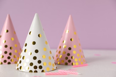 Photo of Birthday party hats and candles on light table