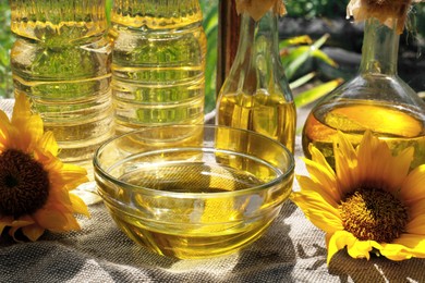 Photo of Organic sunflower oil and flowers on fabric, closeup