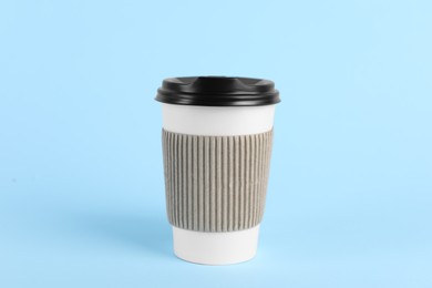 Photo of Paper cup with plastic lid on light blue background. Coffee to go