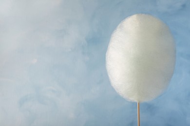 Photo of One sweet cotton candy on light blue background, space for text