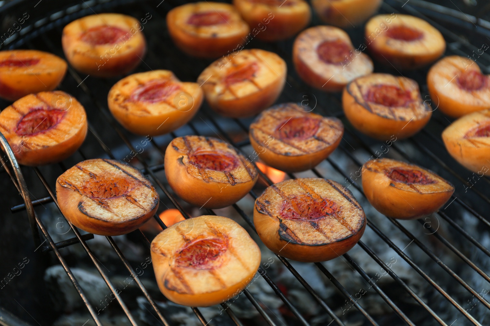 Photo of Modern grill with tasty cut peaches, closeup