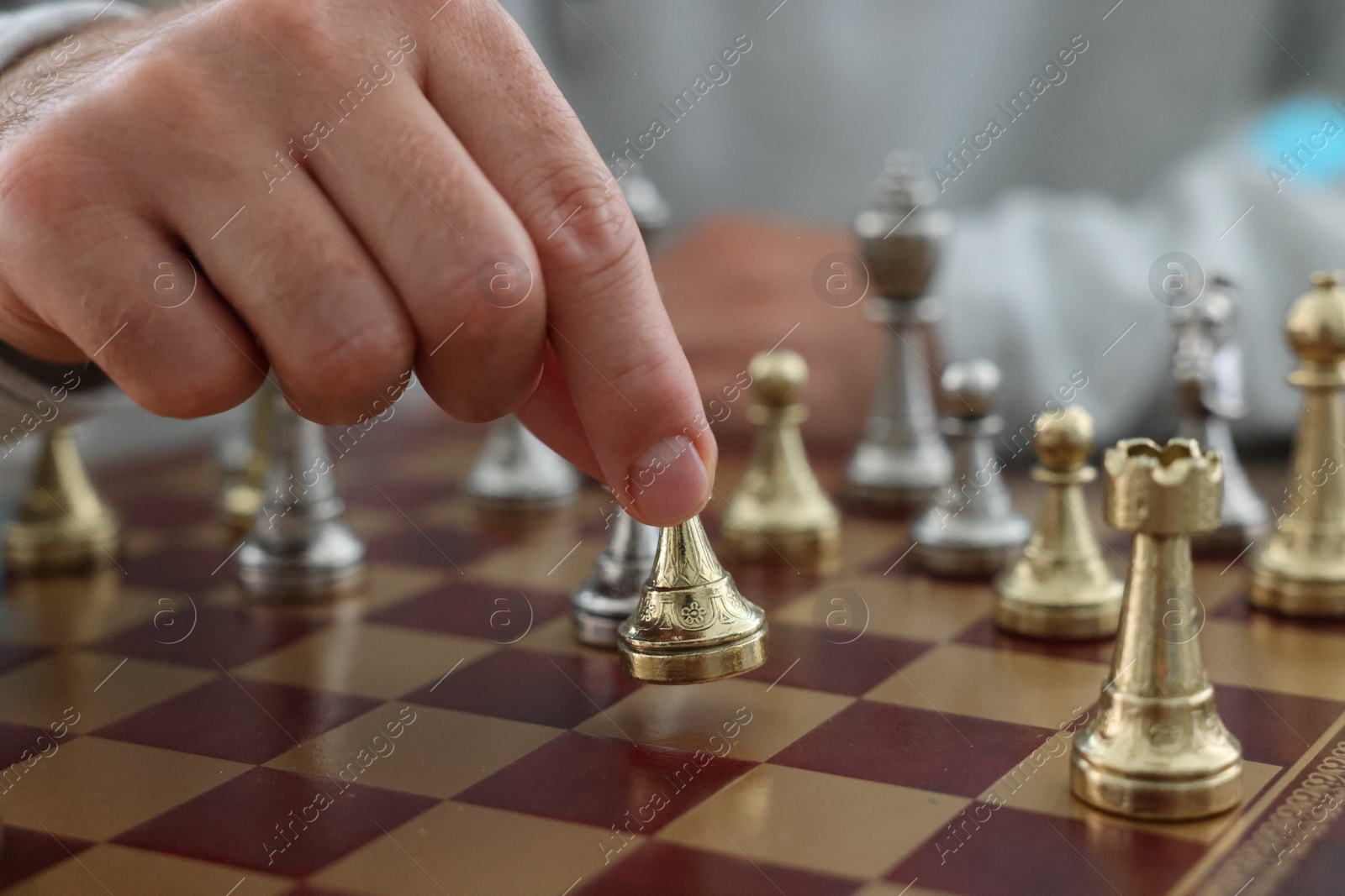 Photo of Man moving chess piece on checkerboard, closeup
