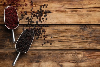 Dried red and black currant berries on wooden table, flat lay. Space for text