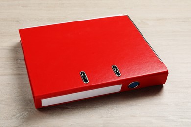 Photo of Red hardcover office folder on white wooden table, closeup
