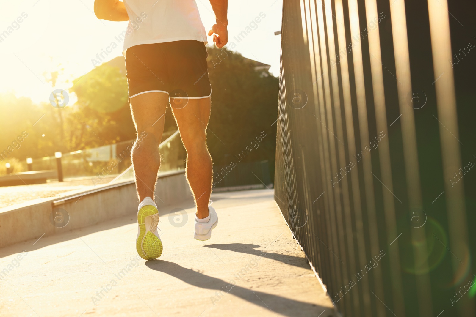 Photo of Man running outdoors on sunny day, closeup. Space for text