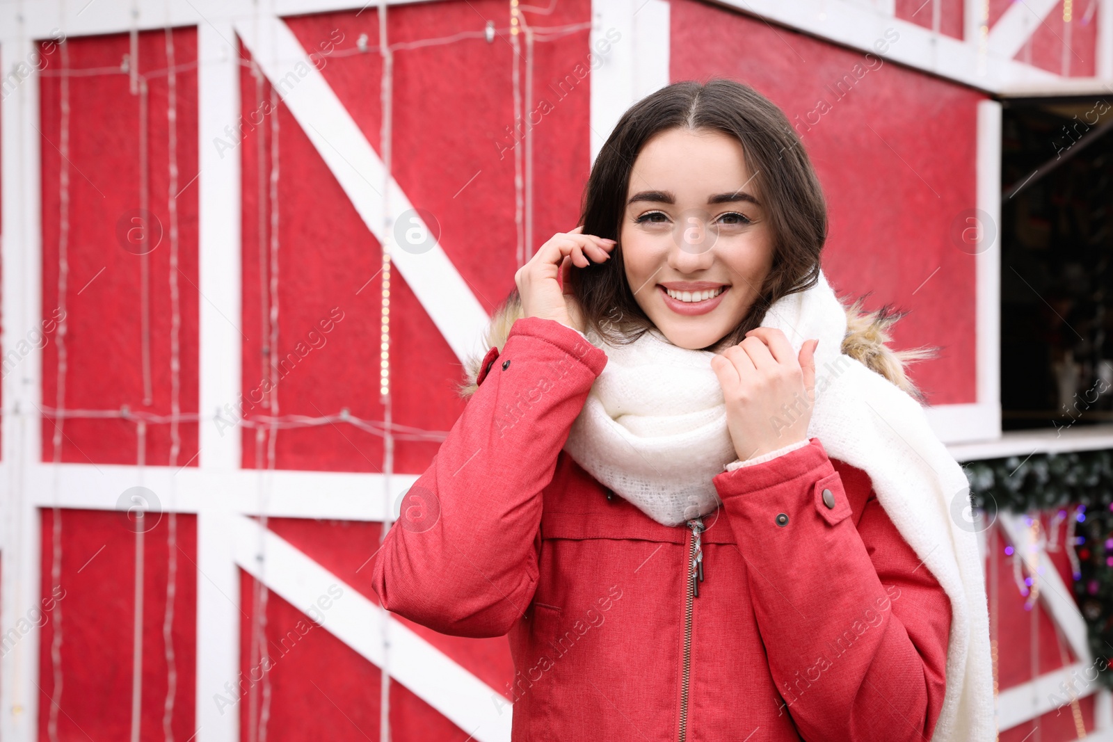 Photo of Young woman spending time at winter fair. Christmas celebration