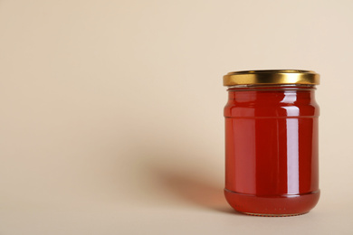 Photo of Jar of organic honey on beige background. Space for text