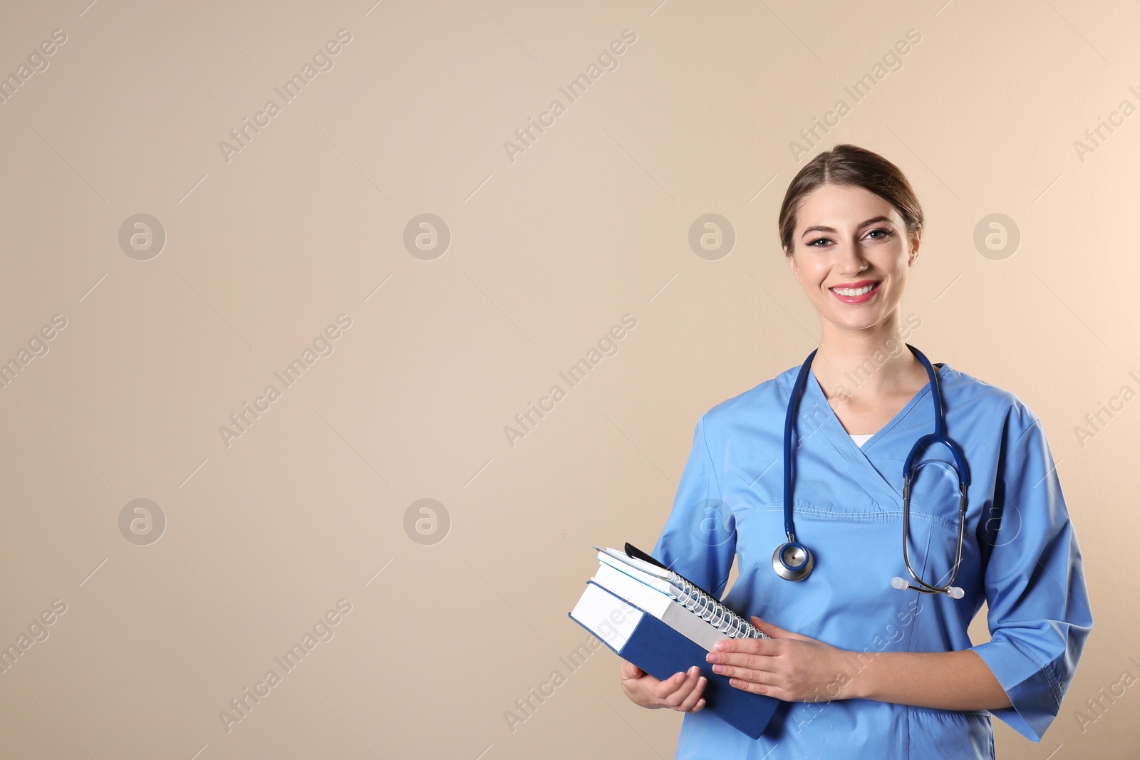 Photo of Young medical student with books on color background. Space for text