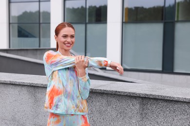 Photo of Beautiful woman in gym clothes doing exercises on street, space for text