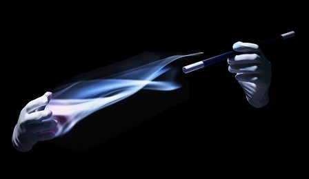 Image of Magician with magic wand performing trick on black background, closeup