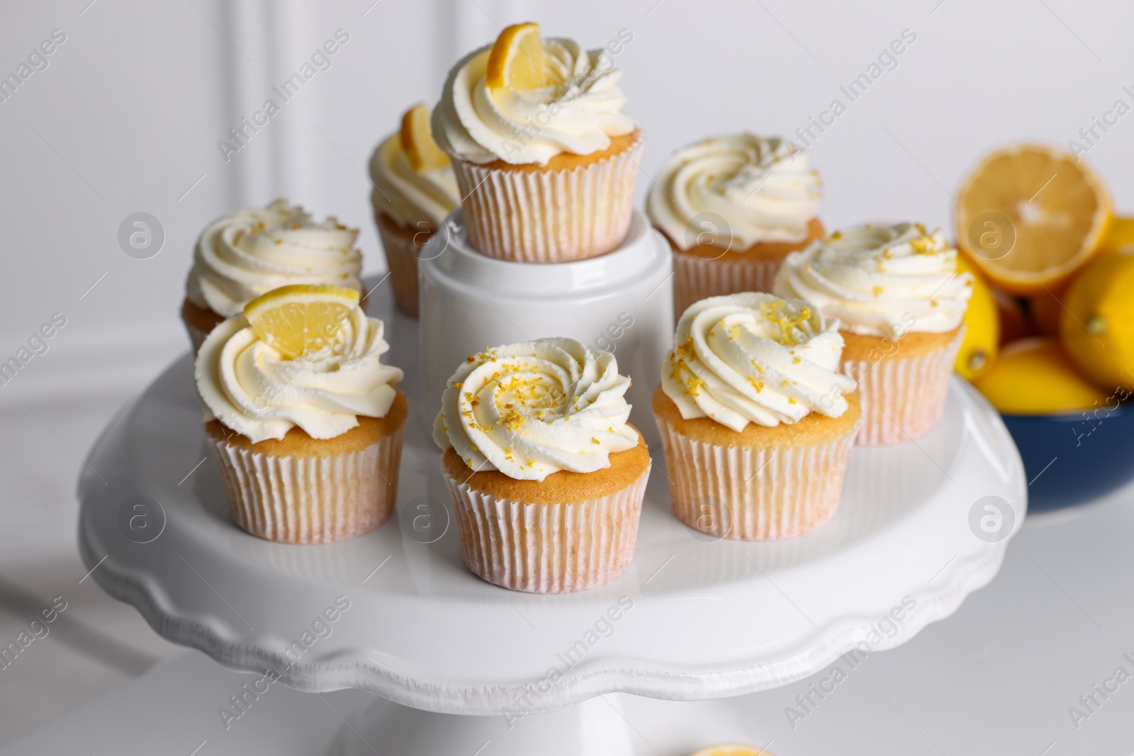 Photo of Delicious lemon cupcakes with white cream on table, closeup