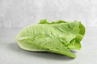 Photo of Fresh green romaine lettuce on light grey table