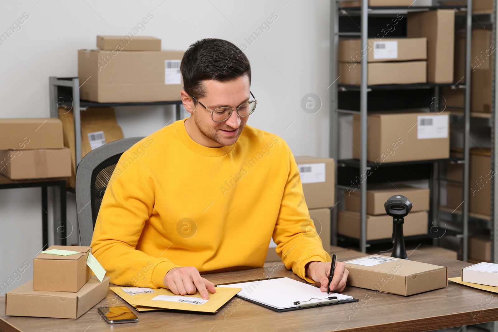 Photo of Seller with parcels working in office. Online store