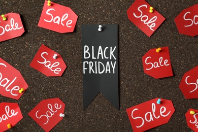 Photo of Tags with phrase Black Friday and Sale on dark cork board