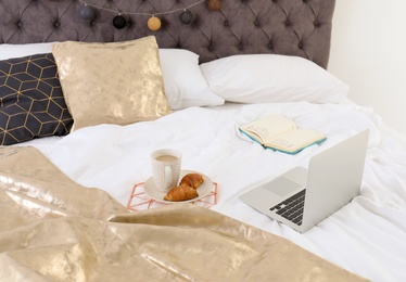 Photo of Laptop and breakfast on bed. Interior element