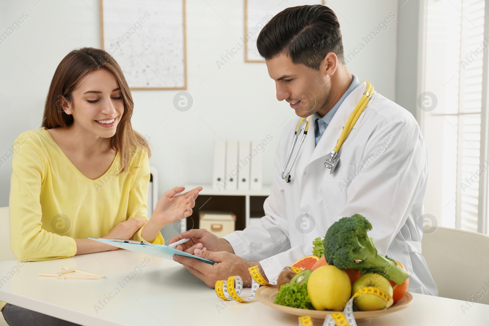 Photo of Nutritionist consulting patient at table in clinic