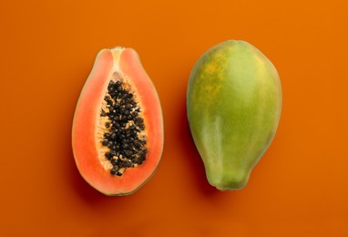Image of Fresh ripe papaya fruits on orange background, flat lay