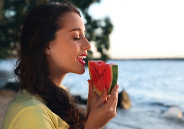 Beautiful young woman with watermelon near river