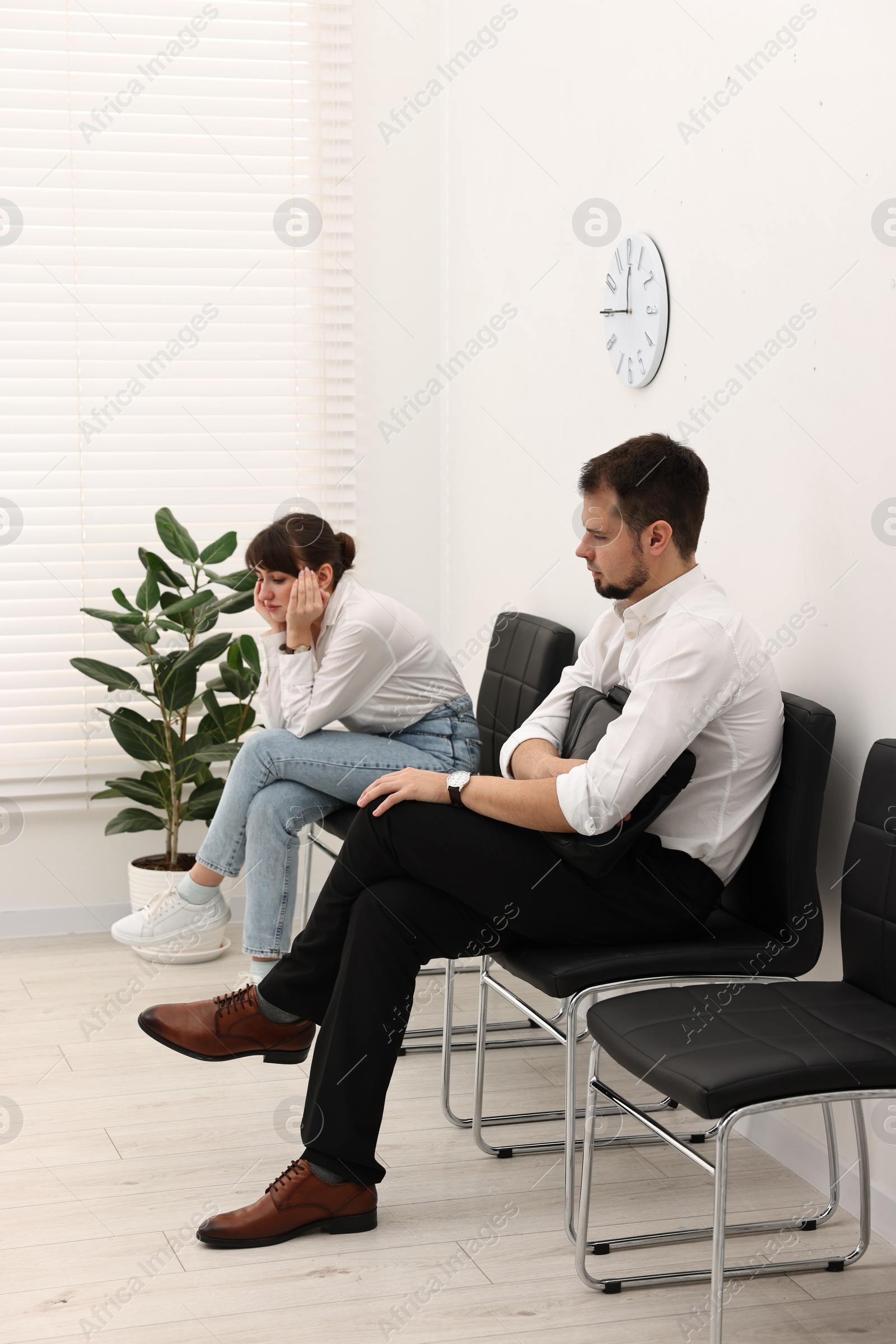 Photo of Man and woman waiting for job interview indoors