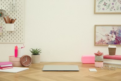 Stylish workplace with laptop on wooden desk near white wall. Interior design