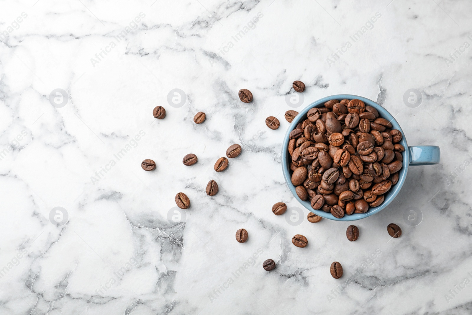 Photo of Cup with coffee beans on marble background