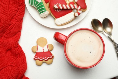 Cup of hot coffee and cookies on white table, top view. Winter drink