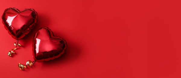 Photo of Heart shaped balloons on red background, flat lay with space for text. Saint Valentine's day celebration