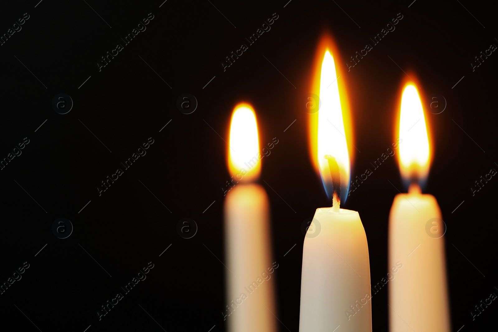 Photo of Burning candles on dark background, space for text. Symbol of sorrow