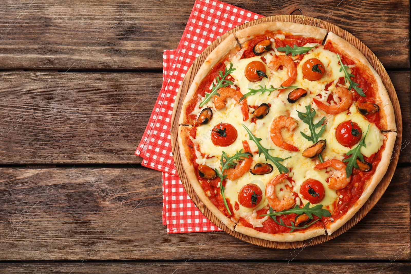 Photo of Delicious seafood pizza on wooden table, top view. Space for text