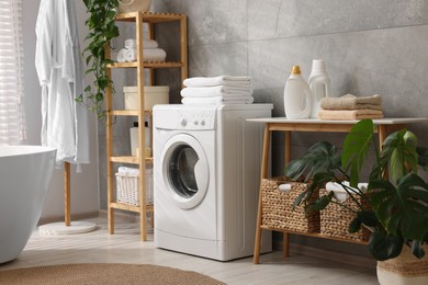 Clean towels, washing machine, plants and deterrents in bathroom